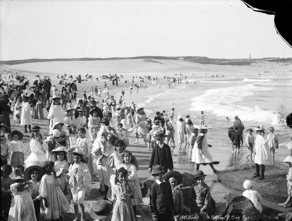 Bondi Beach circa 1900 — crowds in Victorian dress strolling along the shoreline